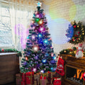 Pre-lit fiber optic Christmas tree glowing in colors beside wrapped presents